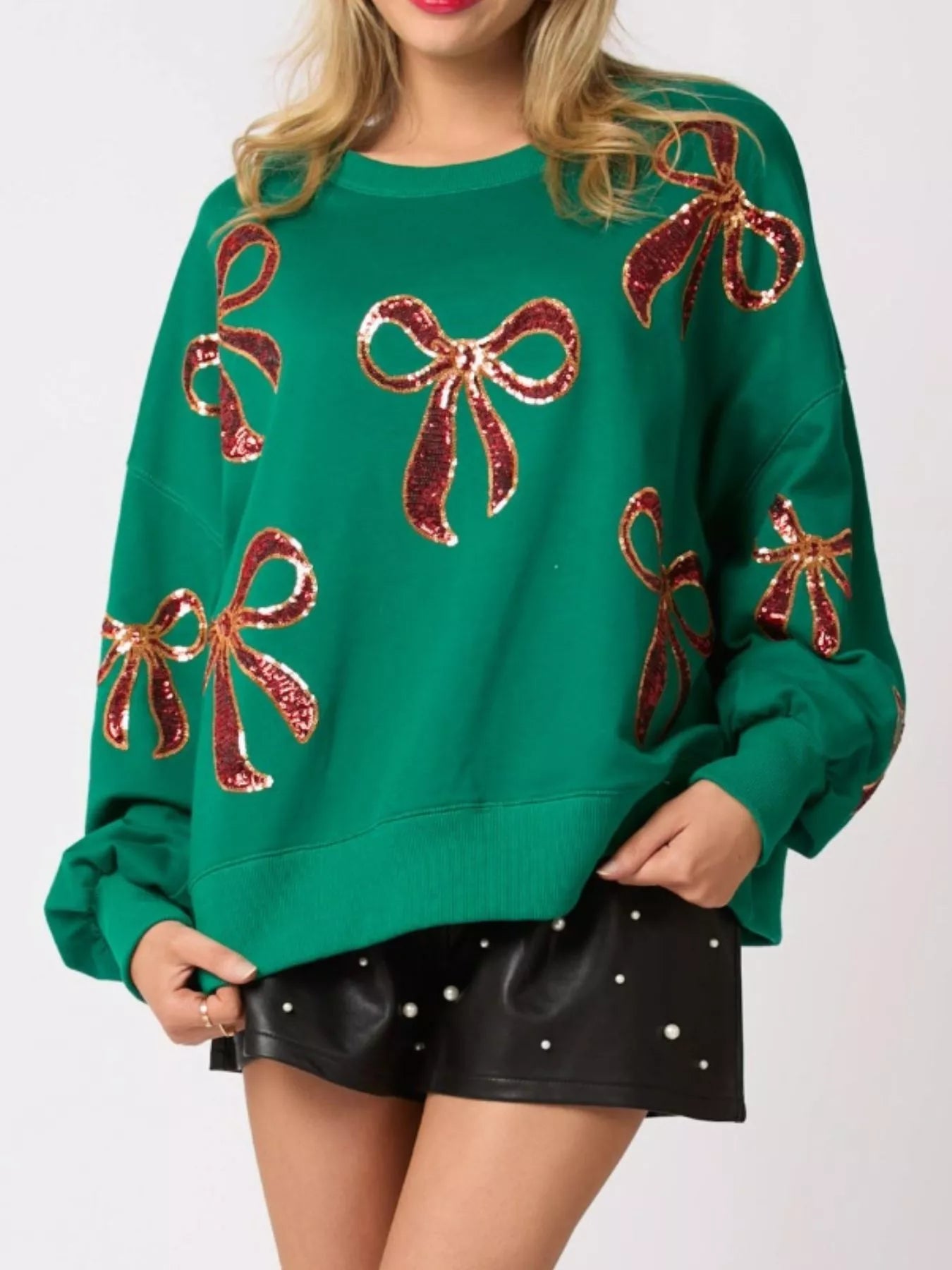 “Front view of women wearing a cozy Christmas sweatshirt with sparkling sequin bow, perfect festive holiday outfit for winter celebrations.”