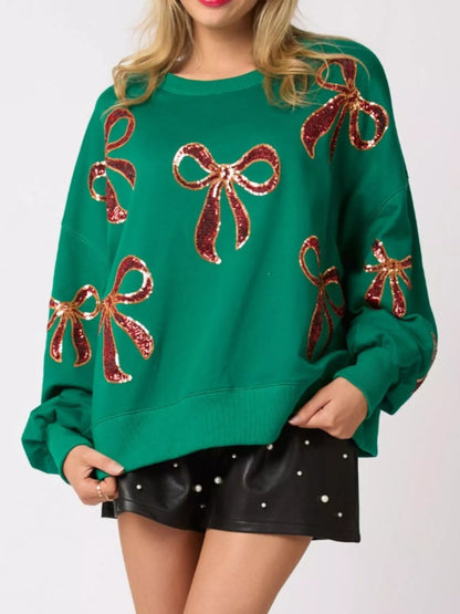 “Front view of women wearing a cozy Christmas sweatshirt with sparkling sequin bow, perfect festive holiday outfit for winter celebrations.”